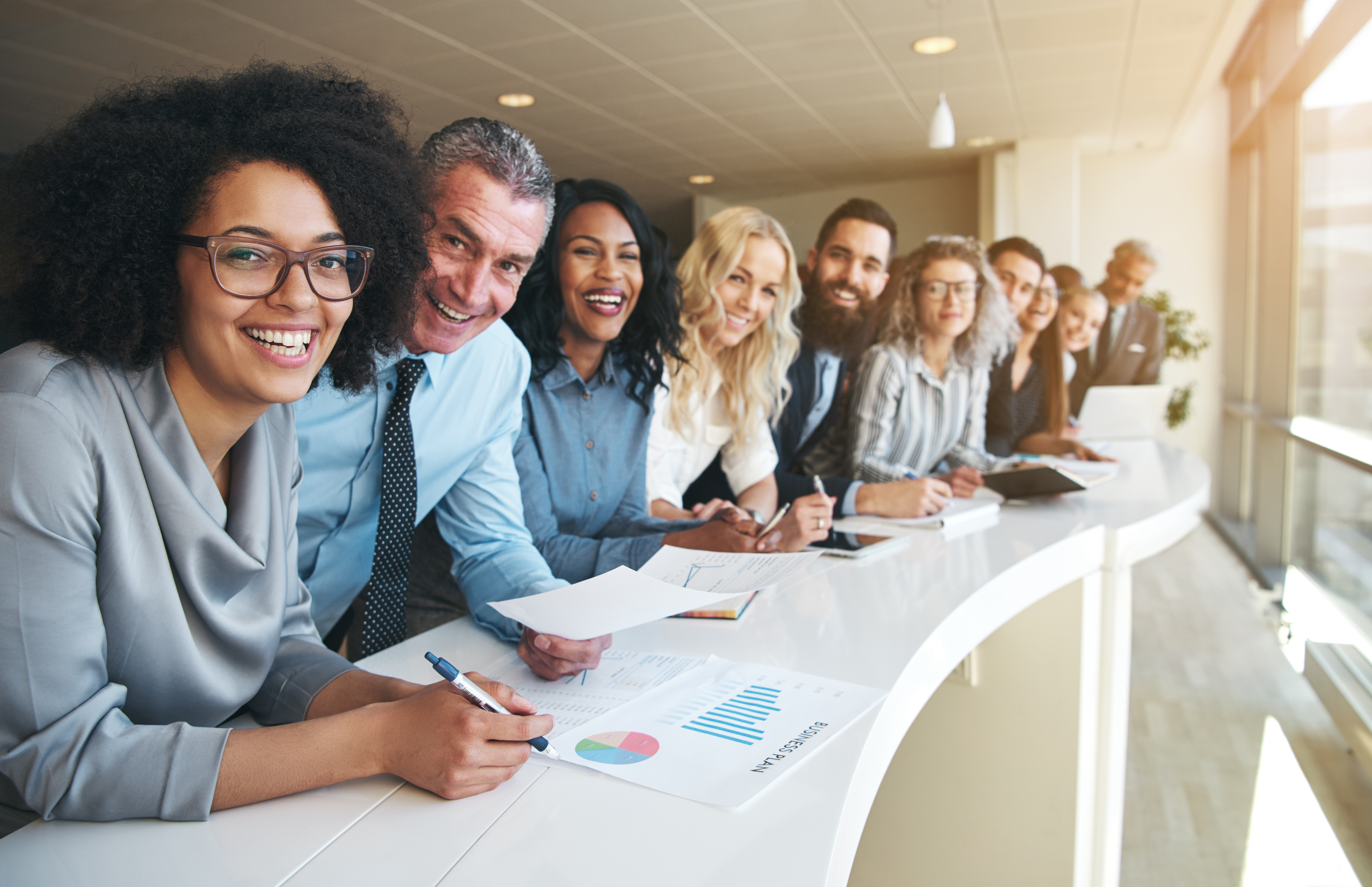 Cheerful multiracial colleagues looking at camera in office